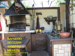 Кухня на улице с барбекю и деревянной мебелью