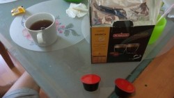 Чашка чая и упаковка кофе на столе