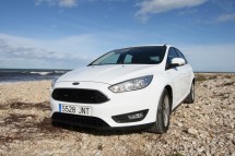 Белый автомобиль на каменистом берегу у моря