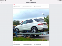 Белый внедорожник на эвакуаторе, человек фиксирует колеса