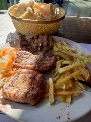 Тарелка с жареным мясом, картофелем фри и салатом