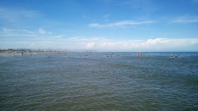Люди купаются на пляже под ясным небом в Испании