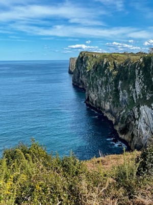 Скалы у моря под голубым небом и облаками
