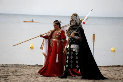 Пара в исторических костюмах на пляже у воды, в Испании