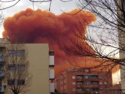 Облако оранжевого дыма над городскими зданиями