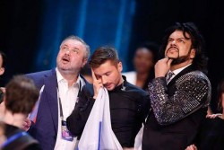 Трое мужчин на сцене, выражающие разные эмоции