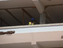 Рабочий в каске на строительном балконе